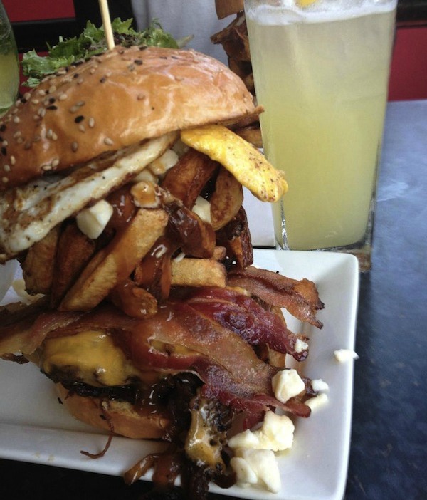 Bacon, Cheese, Caramelized Onions, Fried Egg, Stack of Poutine on a Burger.